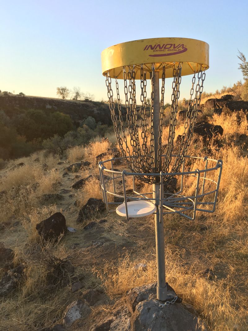 A yellow basket on a rocky desert hillside lit gold by low sun